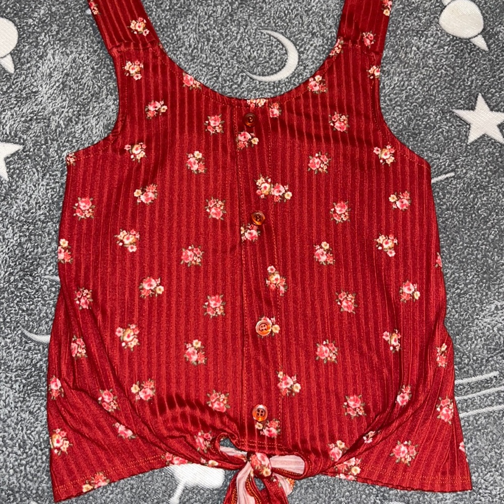 This is a red cute flower shirt it is a cropped top but it’s size 10👍
